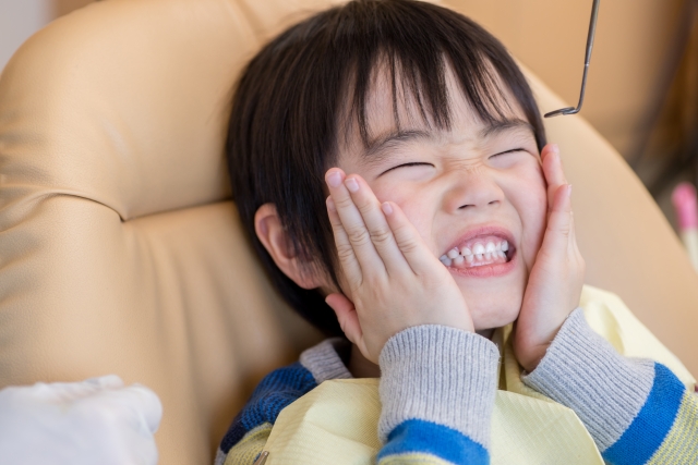 顔を押さえる男の子